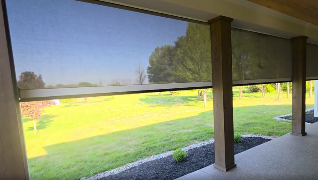 Retractable shades, retracted halfway down, in a backyard patio.