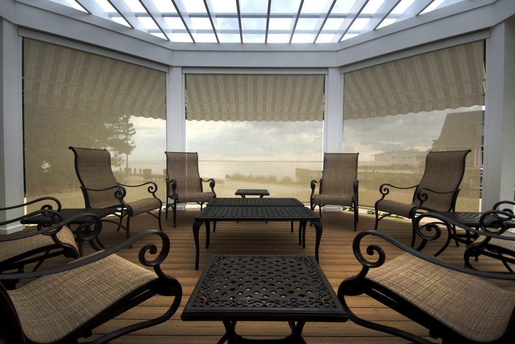 Sheltered seating area completely screened-in by interior roller shades.