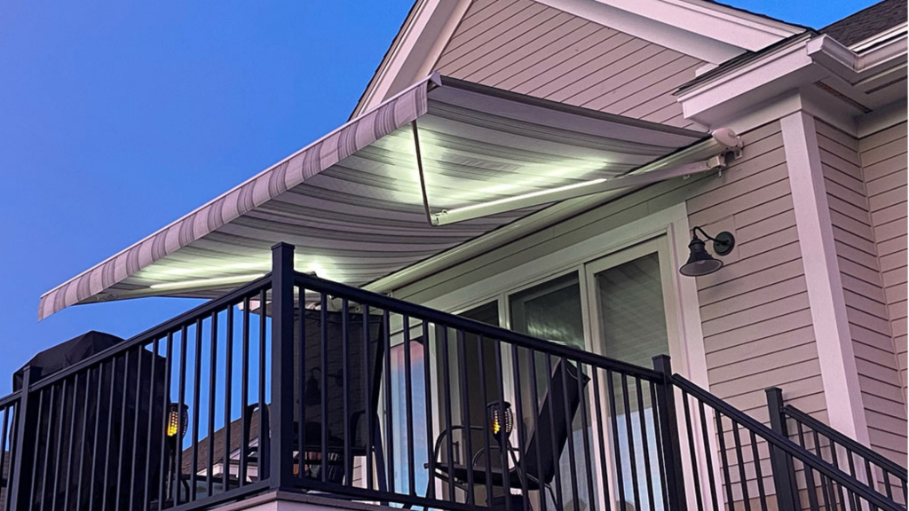 White awning with attached LED lighting fixtures over a raised deck.